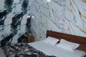 a bedroom with a bed and a wall with aitating at Hotel Indian Lemon Tree in Jīnd