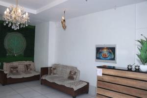 a living room with two chairs and a chandelier at Hotel Indian Lemon Tree in Jīnd +1 photo