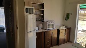 a kitchen with a white refrigerator and a microwave at Westcoast Central Budget accommodation in Vredenburg