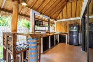 a kitchen with a counter and a refrigerator at Breathe Villa Meno in Gili Meno