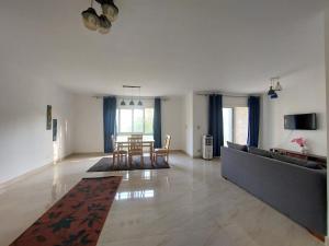 a living room with a table and a couch at Madinaty B12 Guesthouse Shared Apartment - Garden View in Madinaty