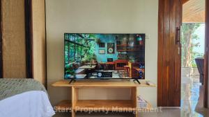 a living room with a tv on a wall at Epic Views Cabins - Ocean or Mountains, your choice in Ko Phangan