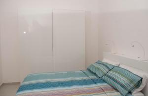 - une chambre blanche avec un lit et un oreiller dans l'établissement Tony's House, à Bari