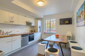 a kitchen with white cabinets and a wooden table at Hostel-Marburg-one Dorms in Marburg an der Lahn