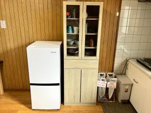 a refrigerator in a kitchen next to a cabinet at ジャンハウス in Takayama