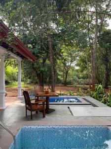 a patio with a table and chairs next to a pool at Voyager's Villa in Habarana