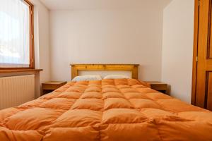 a large orange bed in a room with a window at Casa Irene in Mareson