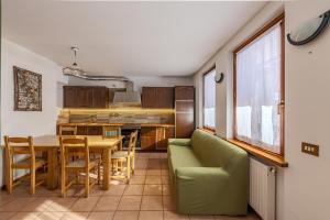 a kitchen and dining room with a green couch and a table at Casa Irene in Mareson
