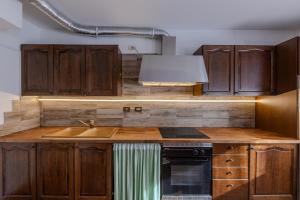 a kitchen with wooden cabinets and a sink at Casa Irene in Mareson +3 photos