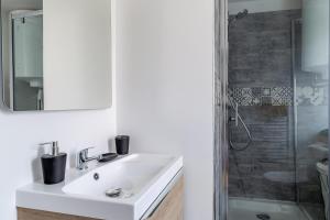 a white bathroom with a sink and a shower at l'escale in Bourg-en-Bresse