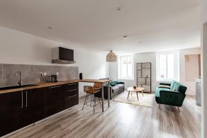 a kitchen and living room with a couch and a table at l'escale in Bourg-en-Bresse