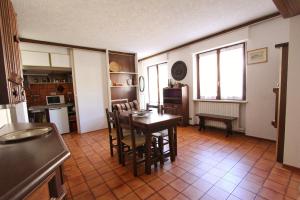 una cucina e una sala da pranzo con tavolo e sedie di Hostdomus - Bi Level Apartment a Pragelato