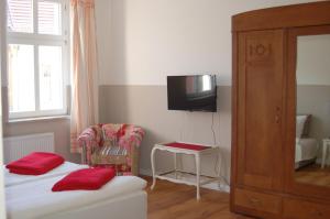 a room with two beds and a tv and a chair at Schloss-und Seeblick Apartment in Rheinsberg