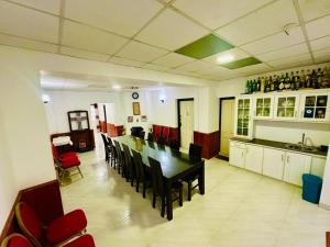 a dining room with a long table and red chairs at Silver Meir Villa in Nuwara Eliya