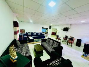 a living room with couches and chairs and a television at Silver Meir Villa in Nuwara Eliya