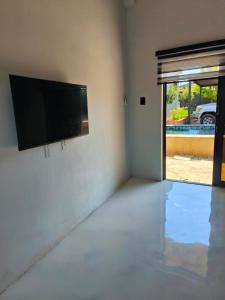 a living room with a flat screen tv on a wall at the Host at Bingos House Self Catering in Thohoyandou