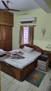 a bedroom with a bed with a wooden frame and a window at Gem Backpackers hostel in Siliguri