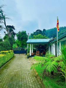a house with a blue roof and a brick driveway at Silver Meir Villa in Nuwara Eliya