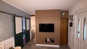 a living room with a television on a wall at Apartment Sabljaci by the Lake in Ogulin