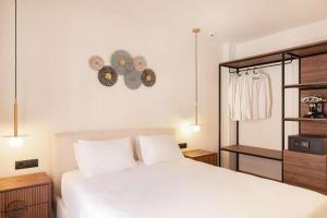 a bedroom with a large white bed and some lights at Aeolis Hotel in Samos