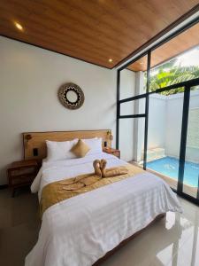 a bedroom with a bed with a large window at Griya Becik Lovina - Private Pool Villa near Lovina Dolphin Spot in Lovina +25 photos