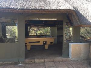an entrance to a house with a thatched roof at Cave view Cottages in Muldersdrift +7 photos