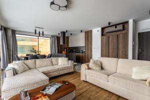 a living room with two couches and a table at Zegrze Riva with the view in Zegrze Południowe +26 photos