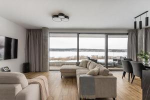 a living room with a couch and a table with chairs at Zegrze Riva with the view in Zegrze Południowe