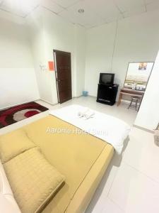 a room with a bed and a tv in it at Aaronie Hotel Setiu in Kampong Burok