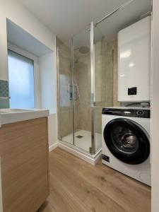 a washing machine in a bathroom with a shower at Ty-Kokoon in Saint-Quay-Portrieux