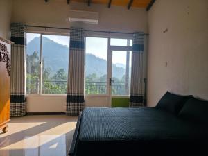 a bedroom with a bed and a large window at X38 Venture in Kitulgala