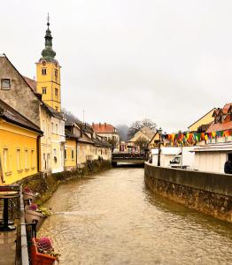 a river flowing through a town with a clock tower at Samobor Old Town Studio by the River in Samobor