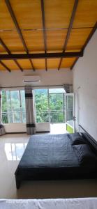 a bedroom with a large bed in a room with windows at X38 Venture in Kitulgala +6 photos