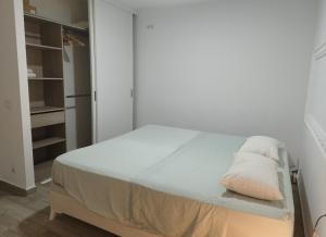 a white bedroom with a bed with a pillow on it at Valencia Room in Cuart de Poblet