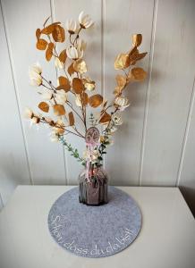 a vase with flowers in it on a table at Sylva Apartment in Sankt Englmar +28 photos