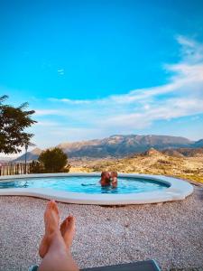 a person in a pool with their feet in the water at Casa Romeriko piscina privada vistas espectaculares Valle de Ricote Murcia in Ricote +34 photos