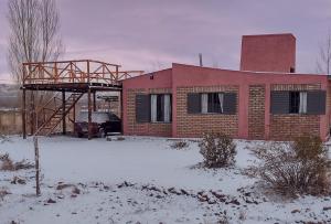 a house in the snow with a car parked in front at Casa Munay para dos personas in Uspallata +12 photos
