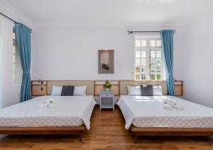 two beds in a room with blue curtains at AnNam Village 4 in Vung Tau +112 photos