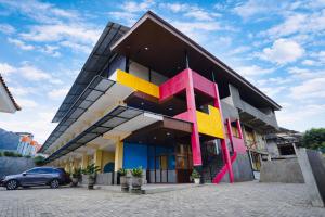 a building with colorful designs on the side of it at Tripletree Kenaro Hotel in Blimbing