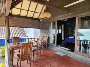 a dining room with a table and chairs on a balcony at Ko Phangan Beach Cottages in Ban Tai