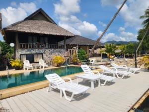 a resort with white chairs and a swimming pool at Ko Phangan Beach Cottages in Ban Tai
