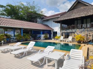 a resort with a swimming pool and white chairs at Ko Phangan Beach Cottages in Ban Tai +19 photos
