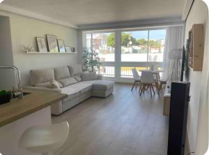a living room with a white couch and a table at Moderno APARTAMENTO CÉNTRICO EN MARBELLA in Marbella