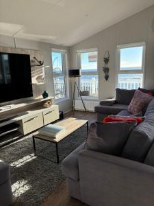 a living room with a couch and a flat screen tv at Seafront Serenity Lodge in Newbiggin-by-the-Sea