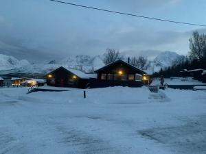 a house in the snow at night with lights at Big cabin in Lyngen Fjords in Jægervatnet