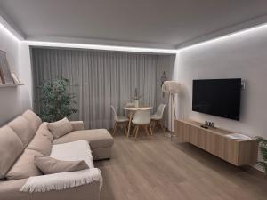 a living room with a couch and a flat screen tv at Moderno APARTAMENTO CÉNTRICO EN MARBELLA in Marbella