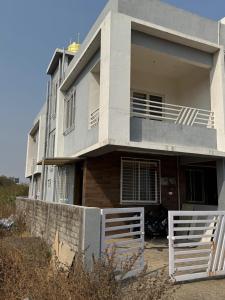 a house with a white fence in front of it at Harmony Palace in Nashik