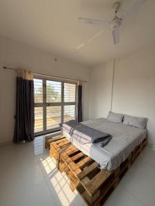 a bed in a room with a large window at Harmony Palace in Nashik +9 photos