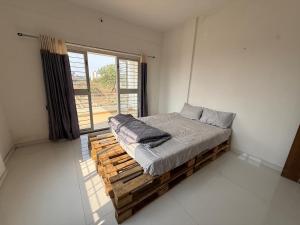 a bed in a room with a large window at Harmony Palace in Nashik