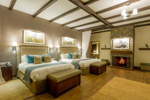 a bedroom with two beds and a fireplace at The Retreat at Ngorongoro in Karatu +45 photos